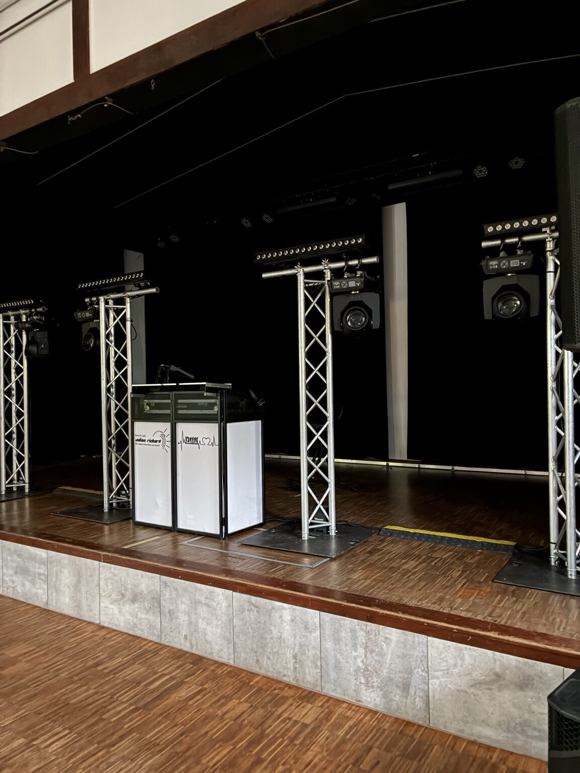 Unbeleuchteter DJ- und Traversensystem-Aufbau in einer Schützenhalle
