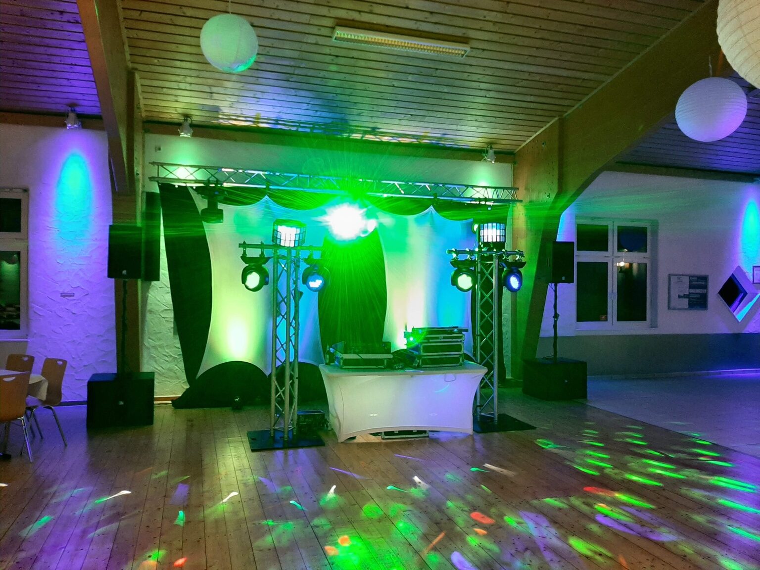 DJ-Aufbau in Würdinghausen mit grün-blauer Lichtshow und Tanzfläche